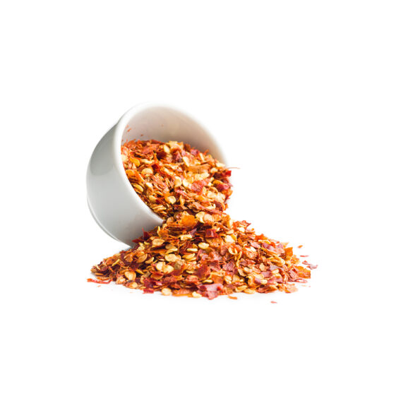 Eva Spices red chilli flakes being sprinkled over a dish of pasta or pizza for an extra kick.
